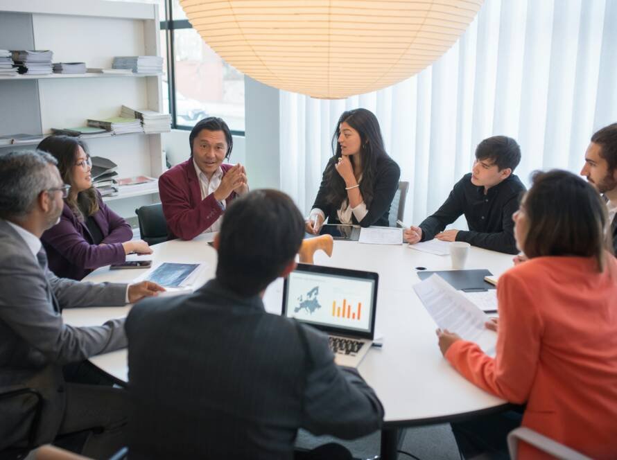 Hotel leadership team planning strategy around growth charts and laptops — symbolizing the 2026 playbook for independent hotels.