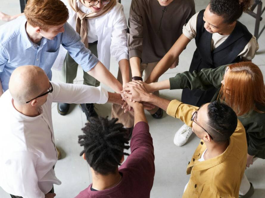 Team uniting hands in collaboration, symbolizing shared leadership and collective success in fractional sales managemen